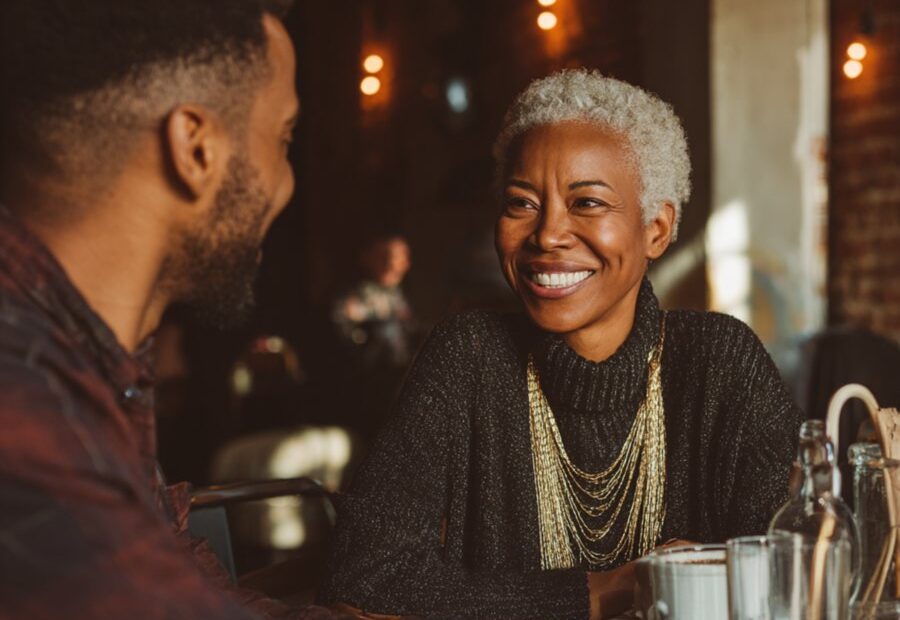 Mature Black woman on a date with younger man in stylish coffee shop